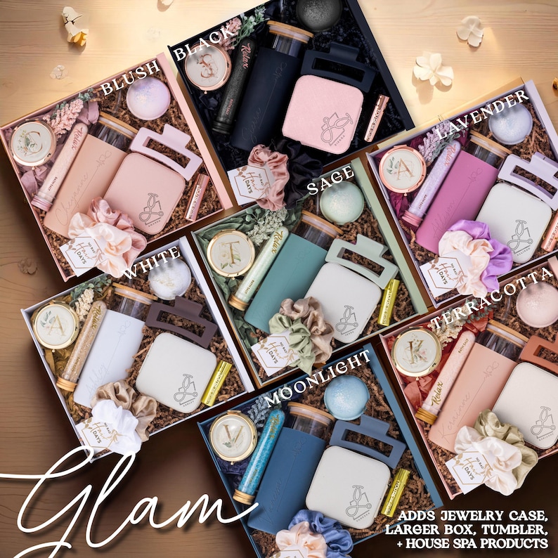 May include: Assortment of gift boxes in various colors, including blush, black, white, sage, lavender, terracotta, and moonlight. Each box contains a tumbler, jewelry case, and spa products. The word "Glam" is written in cursive.