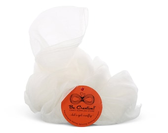 May include: A bundle of white tulle fabric, loosely arranged, with a round orange tag attached. The tag reads "Be Creative! CRAFT SUPPLIES STORE" and "let's get crafty" with text about felting, spinning, knitting, and more.