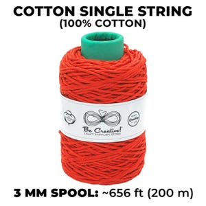 May include: A spool of vibrant red cotton string, labeled "COTTON SINGLE STRING (100% COTTON)". The label reads "Be Creative! CRAFT SUPPLIES STORE". The spool is 3 mm thick and contains approximately 656 feet of string.