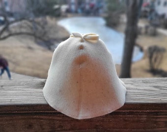 May include: A white felt hat with a pointed top and a small bow on the front.