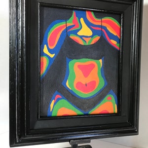 May include: A framed painting of a person's torso with a black swimsuit. The painting is done in a colorful abstract style with a thermal imaging color palette.
