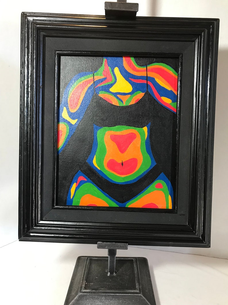 May include: A framed painting of a colorful abstract figure in a black swimsuit. The figure is painted in shades of red, orange, yellow, green, and blue. The painting is framed in a black frame.