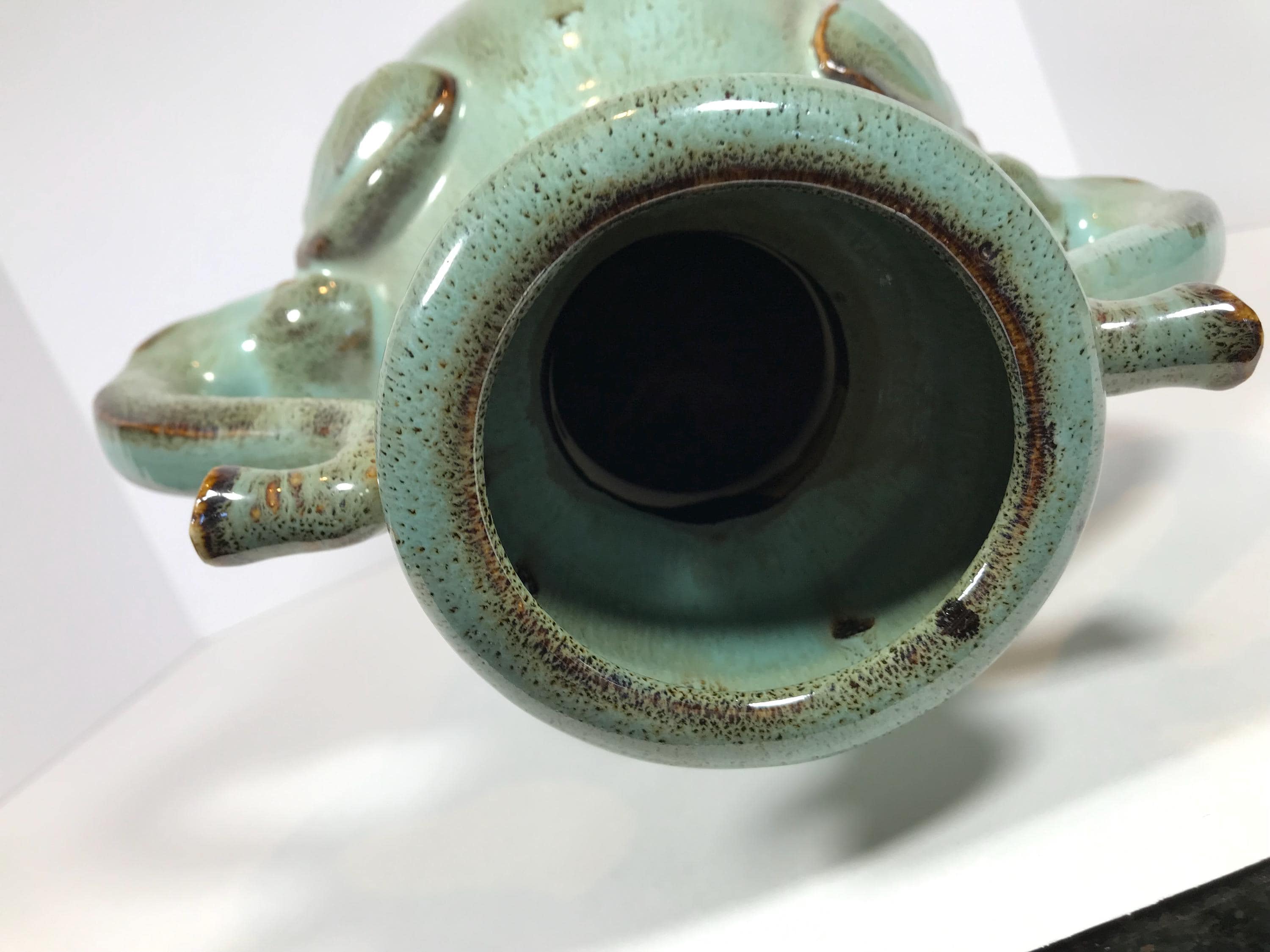 琥珀色の釉薬をかけた陶器のターコイズブルーの象の頭の取っ手が付いた
