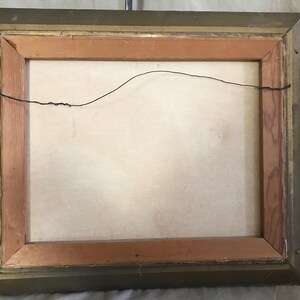 May include: A wooden picture frame with a gold finish. The frame has a wire hanger on the back.