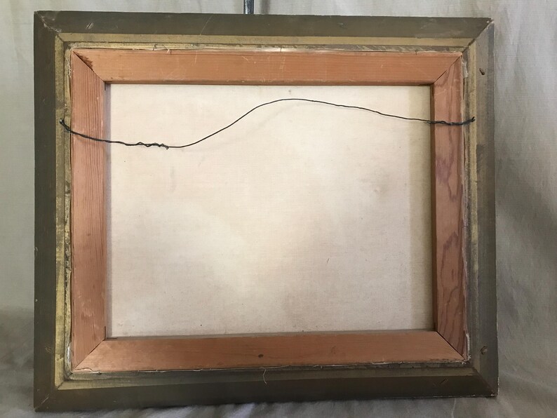 May include: A wooden picture frame with a gold finish. The frame has a wire hanger on the back.