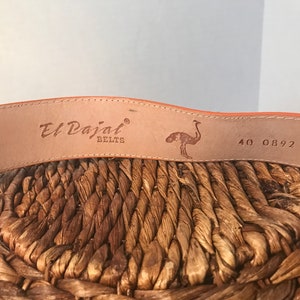 Op de afbeelding: Close-up van een bruine leren riem met de tekst "El Dajal Belts" en een struisvogelontwerp. De riem heeft ook de nummers "40 0892" erop gedrukt.