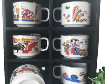 Zestaw filiżanek do kawy z flagami świata marki Hellerware w drewnianym etui, porcelanowe kubki z flagami świata w kolorze białym i złotym, marki Hellerware