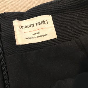 Puede incluir: Falda negra con cierre de cremallera y una etiqueta blanca que dice "(emory park)" talla mediana dise&ntilde;ada en Los &Aacute;ngeles.