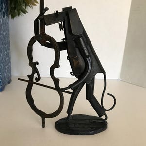 Vintage brutalist style metal dog playing Cello statue, welded metal dog playing musical instrument, contemporary style musical statue