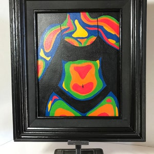 May include: A framed painting of a person's torso in a black swimsuit. The painting is done in a thermal imaging style, with colors ranging from blue to red.
