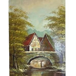 May include: Oil painting of a European village scene. Two houses with red and green roofs sit behind a stone bridge over a river. Trees with yellow-green leaves frame the houses and bridge. The sky is a mix of blue and white.