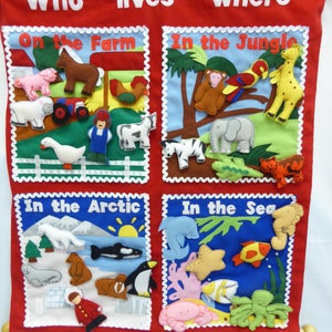 May include: A colorful felt board with the title "Who lives where?" and four sections: "On the Farm", "In the Jungle", "In the Arctic", and "In the Sea". Each section features felt animal figures representing the habitat.