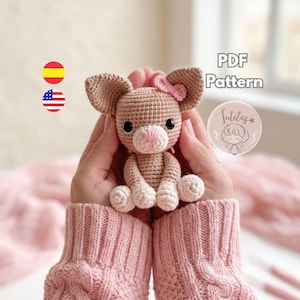 Puede incluir: Un ratón de ganchillo hecho a mano con orejas grandes, un lazo rosa y una nariz rosa. El ratón amigurumi se sostiene en las manos de una persona, con el texto "PDF Pattern" y un logotipo visible en el fondo.