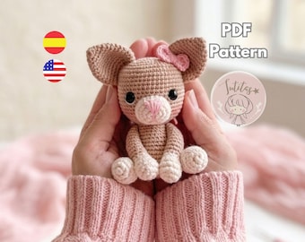 Könnte beinhalten: Eine handgefertigte Häkelmaus mit großen Ohren, einer rosa Schleife und einer rosa Nase. Die Amigurumi-Maus wird in den Händen einer Person gehalten, mit dem Text "PDF Pattern" und einem Logo im Hintergrund.