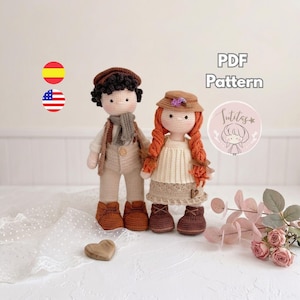 May include: Two handmade crochet dolls featuring a boy with dark curly hair, a brown cap, a grey scarf, and beige overalls, and a girl with long orange braided hair, a brown hat, and a cream-colored dress. The image includes the text PDF Pattern.
