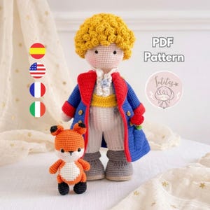 May include: A crochet doll of a boy with curly yellow hair, wearing a blue coat with red trim, a yellow sash, and white pants, standing next to a small orange and white crochet fox. The text PDF Pattern is visible in the upper right corner.