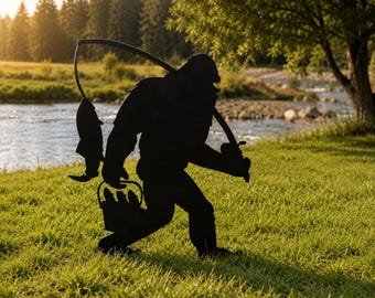 May include: A black metal silhouette of a creature resembling Bigfoot carrying a fishing rod over its shoulder with a fish hanging from the line and holding a bucket filled with several fish in its other hand, standing in a grassy field.