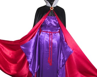 May include: A purple satin dress with a red satin cape. The cape has a black lining and a gold brooch with a red jewel.