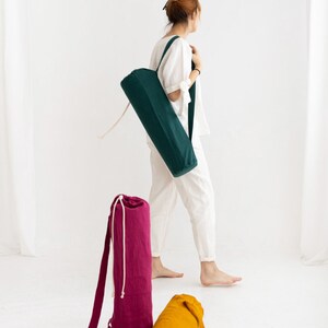 Puede incluir: Tres bolsas para esterillas de yoga en diferentes colores: verde, rosa y amarillo. Las bolsas est&aacute;n hechas de tela y tienen un cierre de cord&oacute;n.