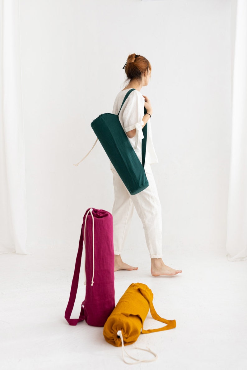 Puede incluir: Tres bolsas para esterillas de yoga en diferentes colores: verde, rosa y amarillo. Las bolsas est&aacute;n hechas de tela y tienen un cierre de cord&oacute;n.