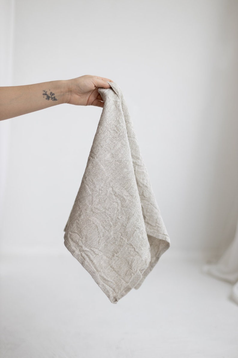 May include: A light gray linen kitchen towel with a textured pattern.