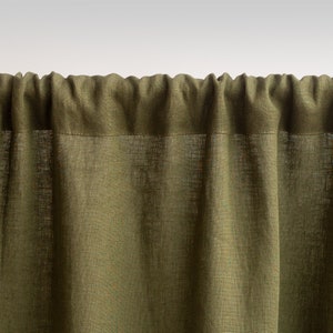 May include: A close-up of a green linen curtain with a subtle texture. The curtain is gathered at the top and hangs in soft folds.