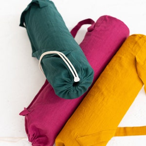 Puede incluir: Tres bolsas para esterillas de yoga en diferentes colores: verde, rosa y amarillo. Cada bolsa tiene un cierre de cord&oacute;n y una correa para llevar.