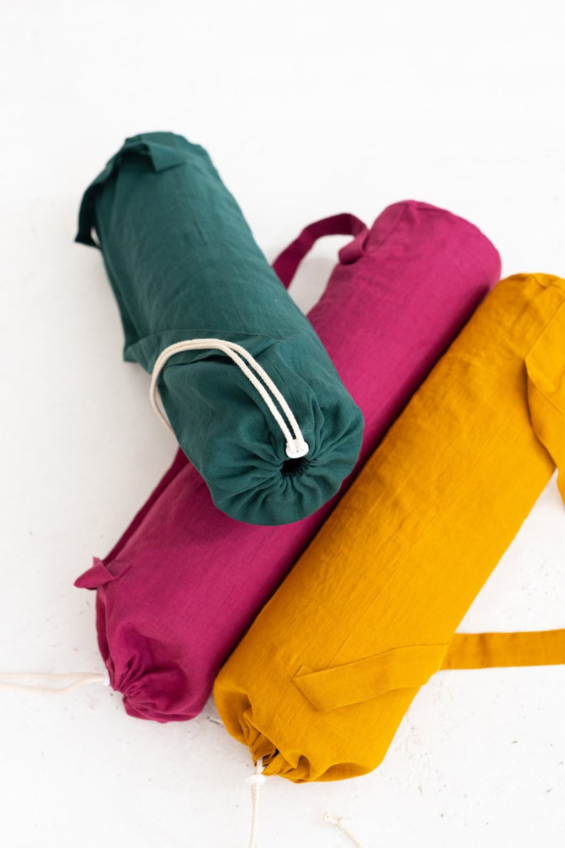 Puede incluir: Tres bolsas para esterillas de yoga en diferentes colores: verde, rosa y amarillo. Cada bolsa tiene un cierre de cord&oacute;n y una correa para llevar.
