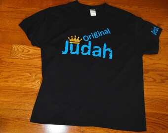 May include: Black t-shirt with a blue and gold design that says "Original Judah" with a crown above the word Judah.