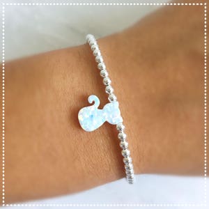 May include: A silver beaded bracelet with a white opal cat charm.