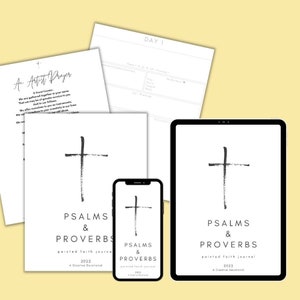 May include: A collection of white paper pages, a smartphone, and a tablet, all featuring a black cross design and the text "PSALMS & PROVERBS" and "2022 A Creative Devotional". Additional pages include "An Artist Prayer" and "DAY 1" headings.