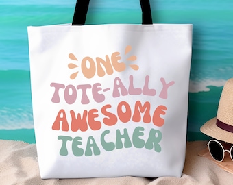 Può includere: Borsa tote bianca con manici neri. La borsa ha una grafica colorata che dice "One Tote-Ally Awesome Teacher".
