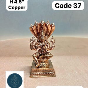 Könnte beinhalten: Eine kupferne Chaturbuja Krishna-Statue, etwa 11,4 cm hoch und 540 Gramm schwer. Die Statue zeigt eine Gottheit mit einem mehrköpfigen Schlangenhimmel. Die Basis ist eine rechteckige Plattform. Der Text "Code 37" ist ebenfalls sichtbar.