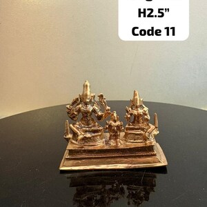 Könnte beinhalten: Eine bronzefarbene Somaskanda Murthy-Skulptur. Die Skulptur zeigt drei Figuren auf einem rechteckigen Sockel. Der Text auf dem Bild lautet: 180 Gramm, H6,35 cm, Code 11.