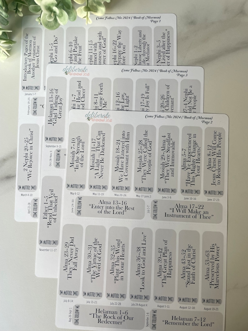 May include: A set of white rectangular stickers with black text. Each sticker features a different scripture reference from the Book of Mormon. The stickers are labeled with the book, chapter, and verses. The stickers are arranged in a grid pattern.