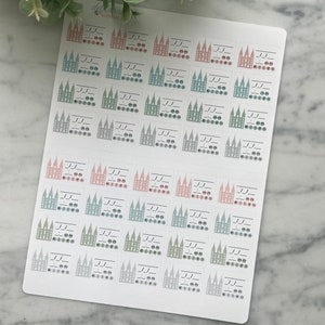 Puede incluir: Una hoja de pegatinas con un patrón repetitivo de ilustraciones de edificios estilizados en colores pastel. Cada pegatina incluye una serie de líneas y círculos, con la palabra "kitzu" en la parte inferior. Las pegatinas están dispuestas sobre un fondo blanco.