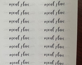 以下が含まれることがあります： 黒い筆記体で「meal plan」という文字が14回繰り返された透明なステッカーのシート。ステッカーは7つのステッカーが2列に並んでいます。シートの上部には、より小さなフォントで「deliberate doodles」という文字が印刷されています。