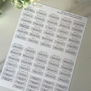 Könnte beinhalten: Ein weißes Blatt Papier mit einem in Grau und Schwarz gedruckten Kalender für den Come Follow Me-Lehrplan 2024. Der Kalender enthält Daten und Schriftstellenverweise für das Buch Mormon.