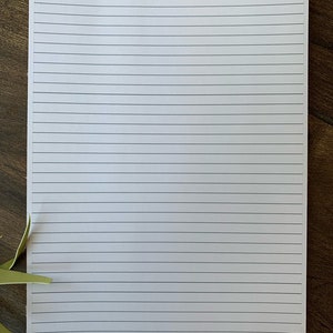 May include: A blank white sheet of paper with lined ruled lines. The paper has the text "deliberate" and "planned joy" printed in the top left corner.