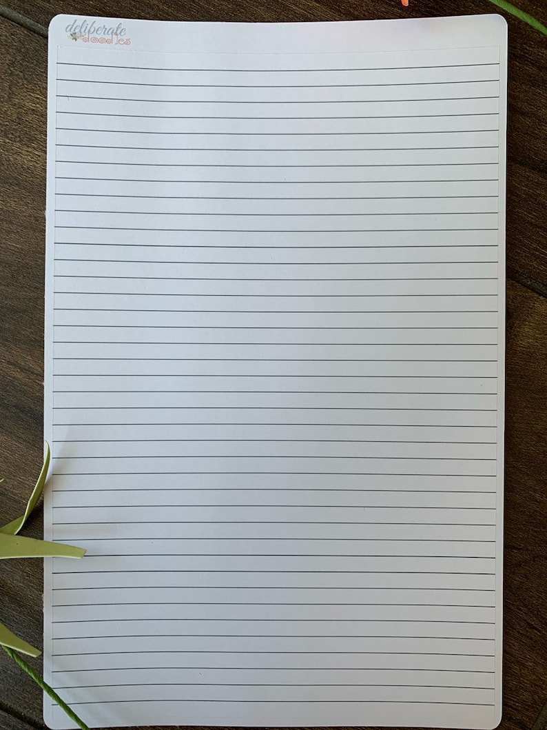 May include: A blank white sheet of paper with lined ruled lines. The paper has the text "deliberate" and "planned joy" printed in the top left corner.