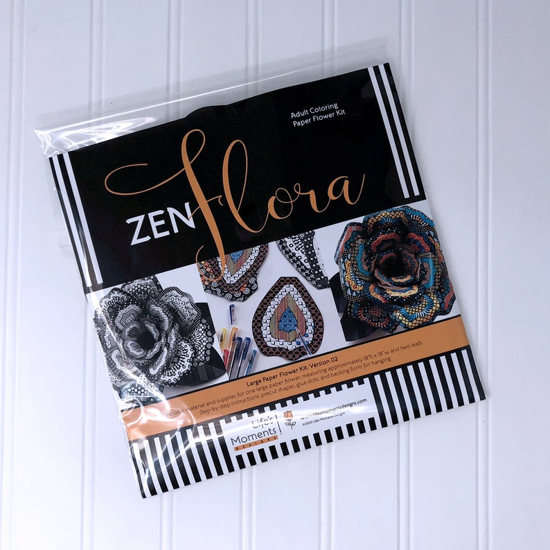 May include: A black and white package with the words "ZENflora" and "Large Paper Flower Kit: Version 02" on it. The package shows a black and white paper flower, a black and white paper teardrop, and a colorful paper flower.
