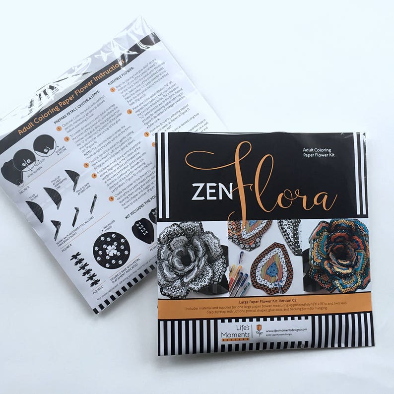 May include: A black and white paper flower kit with instructions on how to assemble the flower. The kit includes a large paper flower, a smaller paper flower, and a center piece. The kit is called "Zen Flora" and is made by Life's Moments.