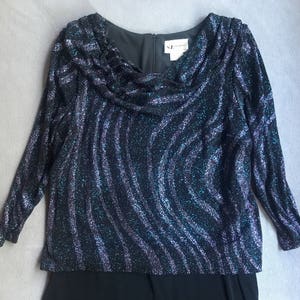 May include: A black and blue sequined long-sleeved dress with a cowl neck and a black skirt. The dress has a label that reads "N.Y.  FASHION".