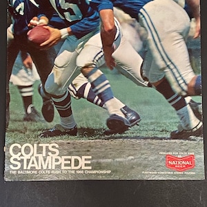 May include: A vintage record album cover featuring a photo of the Baltimore Colts football team in action. The cover is red, white, and blue with the text "COLTS STAMPEDE" and "THE BALTIMORE COLTS RUSH TO THE 1968 CHAMPIONSHIP".