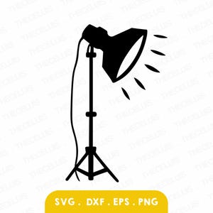 May include: A black silhouette of a studio spotlight on a tripod stand. The spotlight is angled to the right, with light rays emanating from the lamp. The bottom of the image has the text "SVG. DXF. EPS. PNG" on a yellow background.