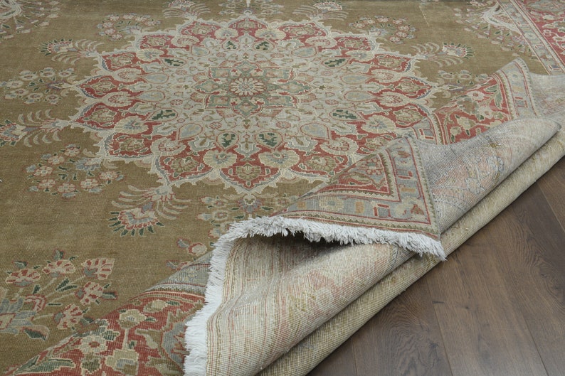 May include: A brown and beige rug with a floral pattern. The rug is folded in half and the underside is visible.