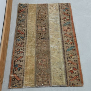 May include: A vintage rug with a cream background and colorful geometric patterns in shades of orange, blue, and brown. The rug has a worn and faded look, adding to its vintage charm.