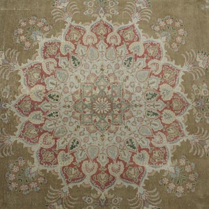 May include: A vintage rug with a central medallion design in shades of beige, red, and blue. The rug has a floral pattern with intricate details.
