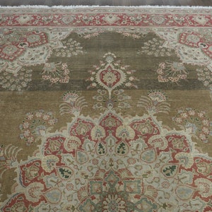 May include: A vintage rug with a detailed floral pattern in shades of red, beige, and green. The rug has a central medallion with a repeating pattern of flowers and leaves.
