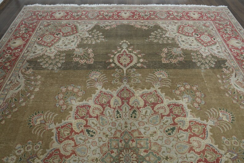 May include: A vintage rug with a detailed floral pattern in shades of red, beige, and green. The rug has a central medallion with a repeating pattern of flowers and leaves.